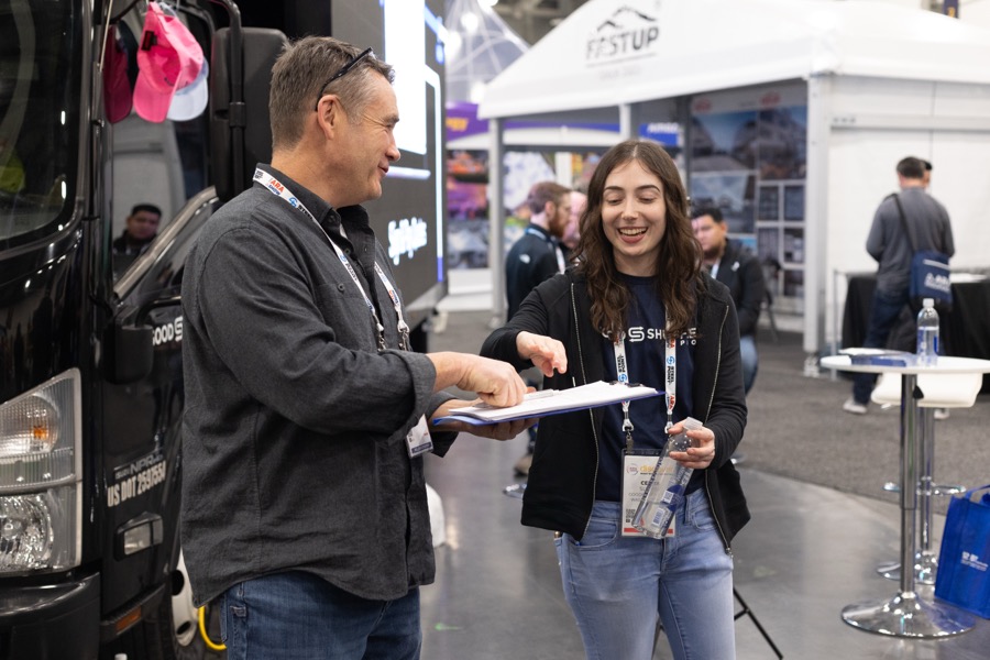Celita Summa talking with a customer at a trade show booth